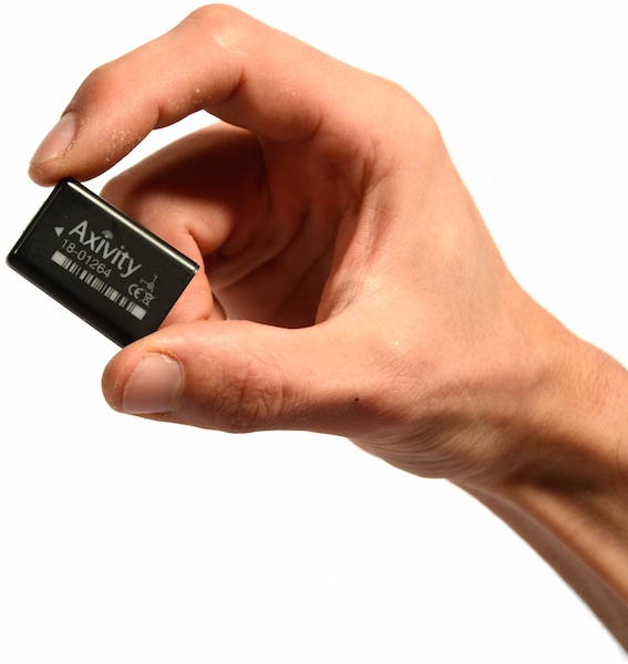 An Axivity AX3 accelerometer held between two fingers, showing its small size